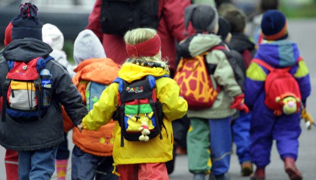 Kinder in Begleitung auf dem Weg zum Kindergarten (Symbolbild).