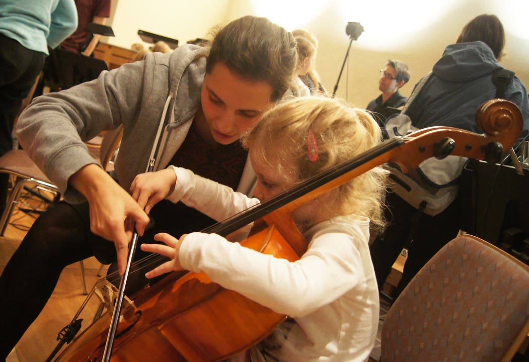 Xenia Burkard erklärt einem Mädchen das Cello