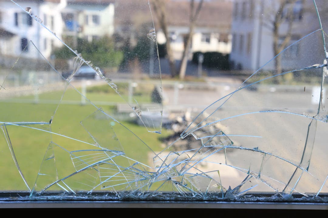 Blick durch zerborstenes Fenster auf den Schulhof.