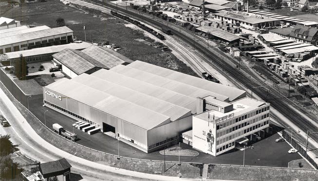 Historisches Foto aus dem Jahr 1963: Der Hauptsitz der Dr. Ing. Koenig AG, die Vorgängerin der heutigen Koenig Feinstahl AG, mit dem markanten, mittlerweile entfernten Ritter an der Fassade. Nördlich der Gleise ist das heutige Industriegebiet Silbern zu erkennen. Im Vordergrund die Überlandstrasse.