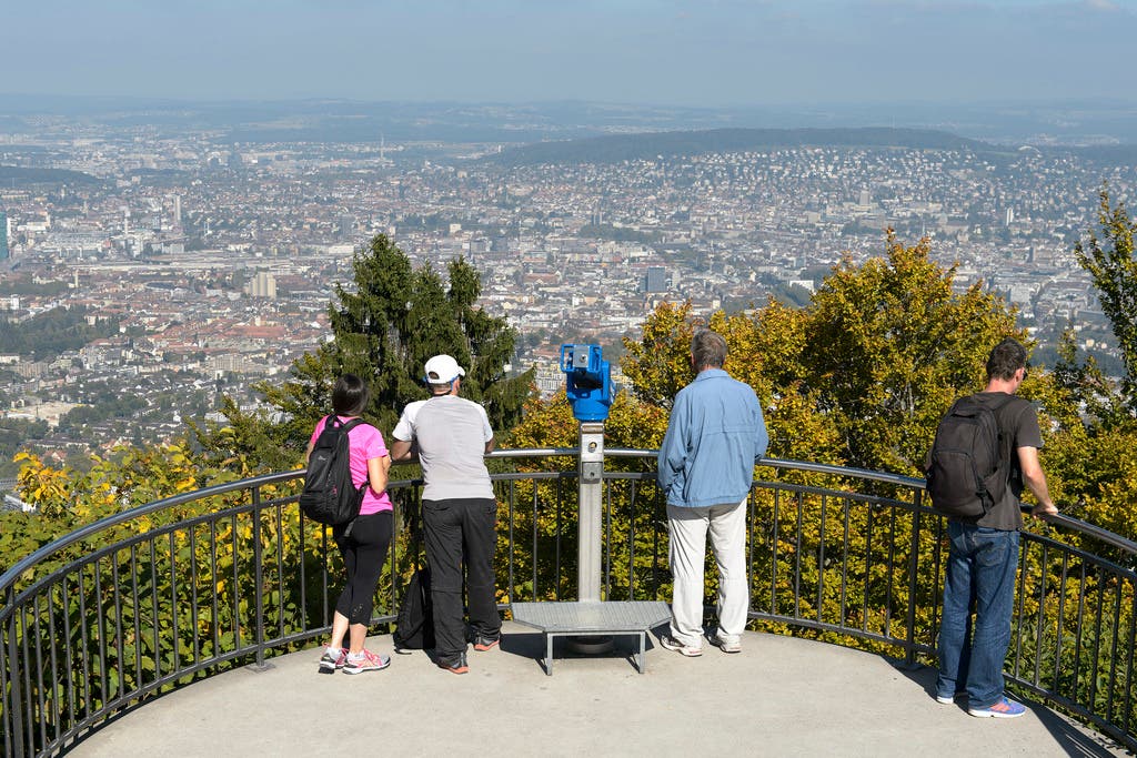 Personen betrachten den Blick auf die Stadt Zuerich vom Zuercher Hausberg Uetliberg (871 m)
