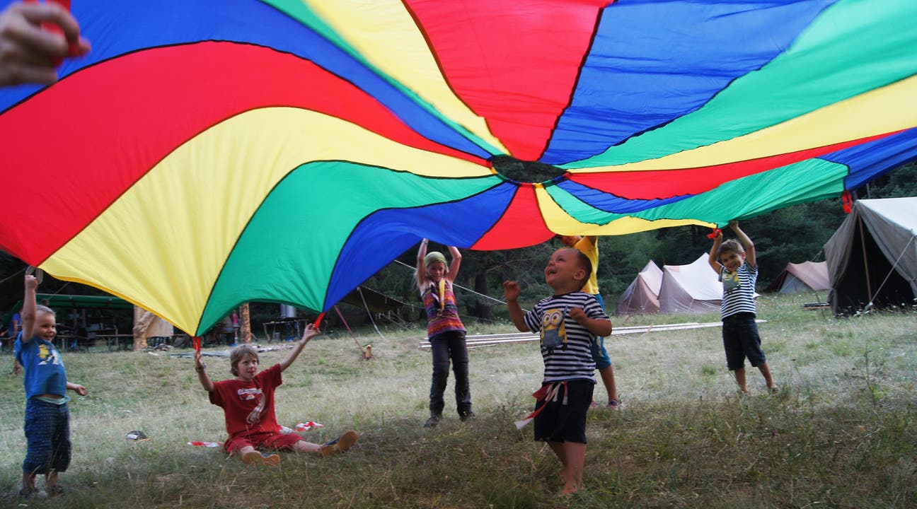 Die Jüngsten im Lager haben Riesenspass am kunterbunten Fallschirm
