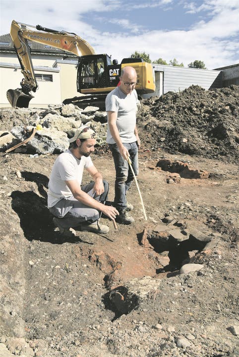 Fabio Tortoli (l.) und Martin Bösch untersuchen einen römischen Töpferofen.