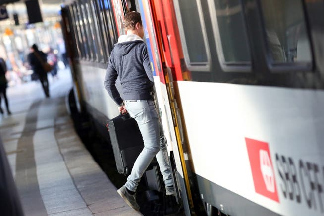 Ein Pendler steigt in einen SBB-Zug ein.