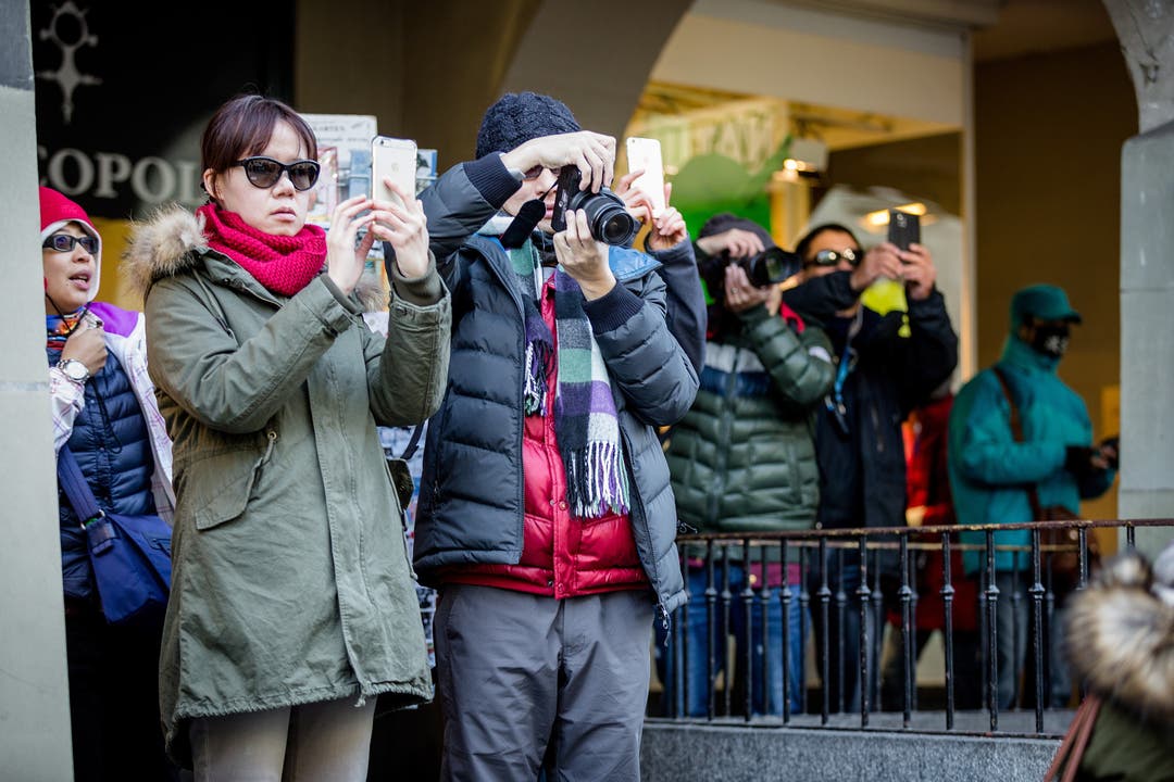Asiatische Touristen fotografieren die Demonstranten.