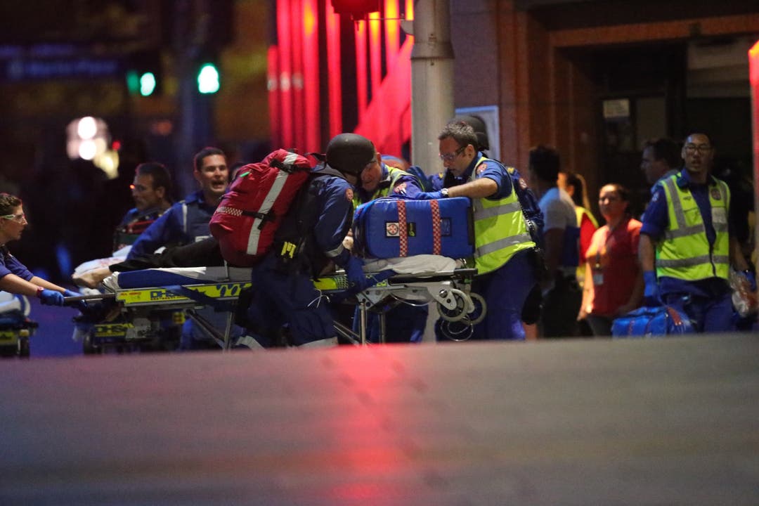 Nach der Stürmung des Cafés: Sanitäter bringen eine verletzte Geisel zu einem Krankenwagen.