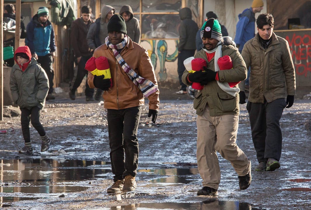 Flüchtlinge kommen mit warmen Decken zurück ins Lager