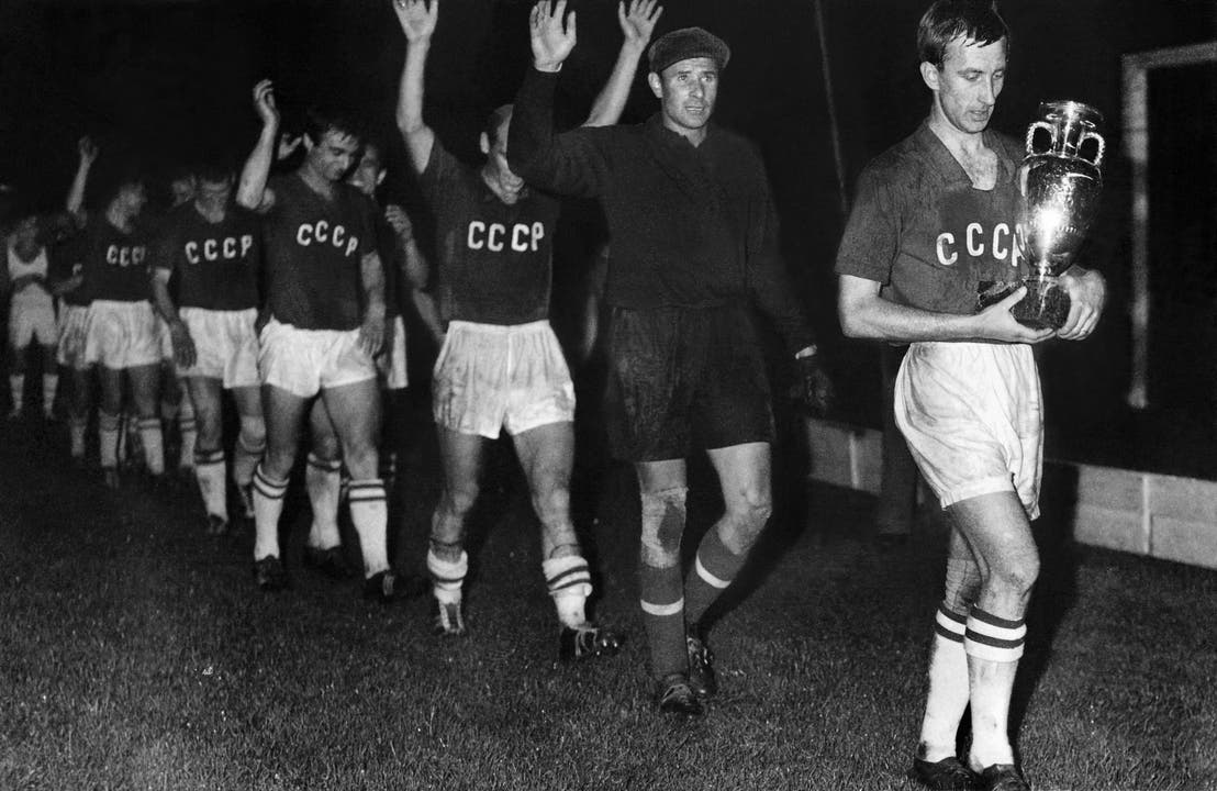 EM 1960: Die sowjetische Mannschaft (UdSSR) schreitet nach ihrem 2:1-Sieg über Jugoslawien im Final m Parc des Princes in Paris in einer Reihe jubelnd über den Rasen. Lew Jaschin, der Torhüter der Mannschaft (2. von rechts) winkt zusammen mit den anderen Spielern hinter dem Captain Igor Netto, der den Pokal trägt, den Zuschauern zu.