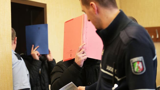 Zwei der drei Angeklagten betreten den Saal des Kölner Amtsgerichts.