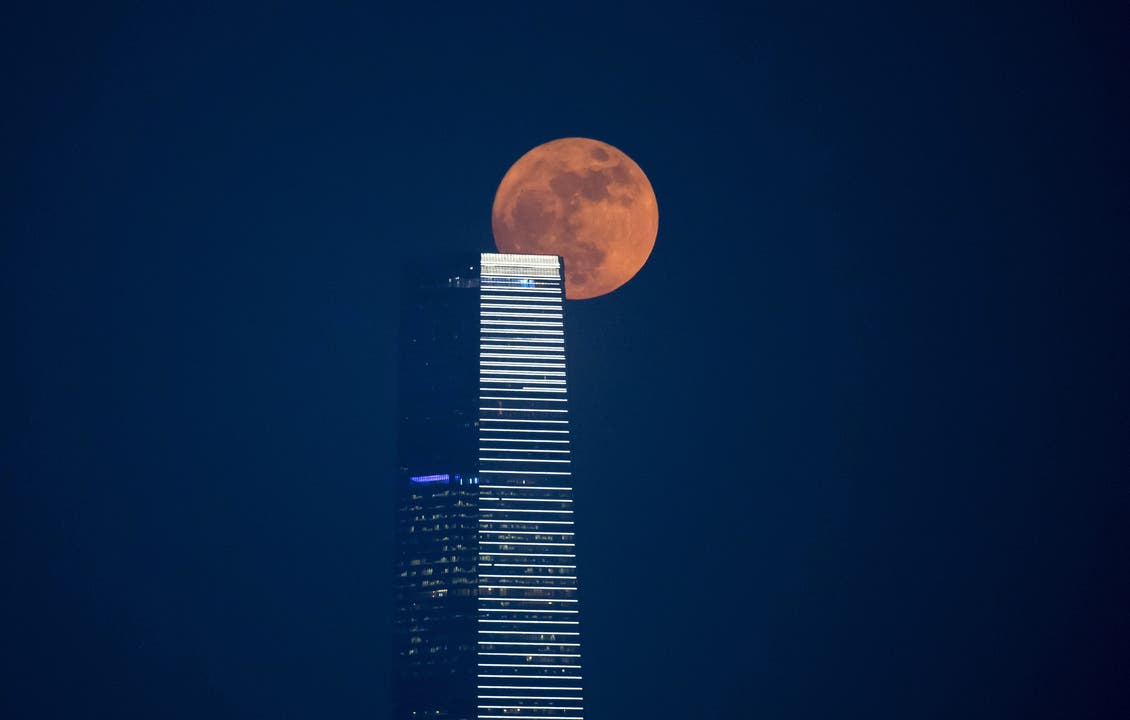 Eindrücklich - der Supermond hinter einem Wolkenkratzer in Hongkong