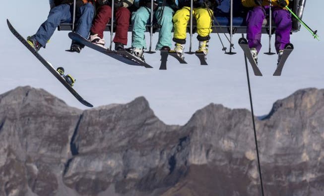 Am letzten Wochenende musste man ihn noch suchen. Nun ist er da – der grosse Schnee: Skifahrer und Snowboarder auf dem Sessellift Ice Flyer auf dem Titlis-Gletscher. Foto Keystone