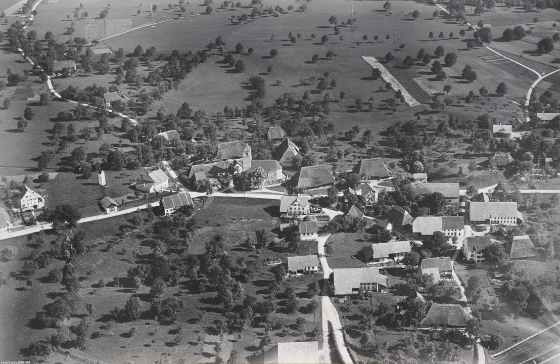 Luftaufnahme von Obergösgen, 1923. Auf dem heutigen Dorfkern-Areal erkennbar (von links): Pfrundhaus («Hälmihaus»), Transformatorenstation, Spritzenhäuschen (alle abgebrochen) sowie das zum Café Egge umgebaute Pfarrhaus an der Strassenkreuzung.