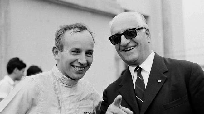 Enzo Ferrari (r.) mit dem erst kürzlich verstorbenen John Surtees (1964). Die italienische Polizei konnte den Diebstahl seiner sterblichen Überreste verhindern.