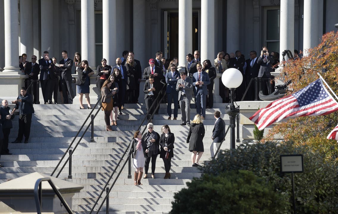 Auch auf den Stufen des Eisenhower Executive Office Building, welches neben dem Weissen Hause steht, warten Personen auf die Ankunft Trumps.