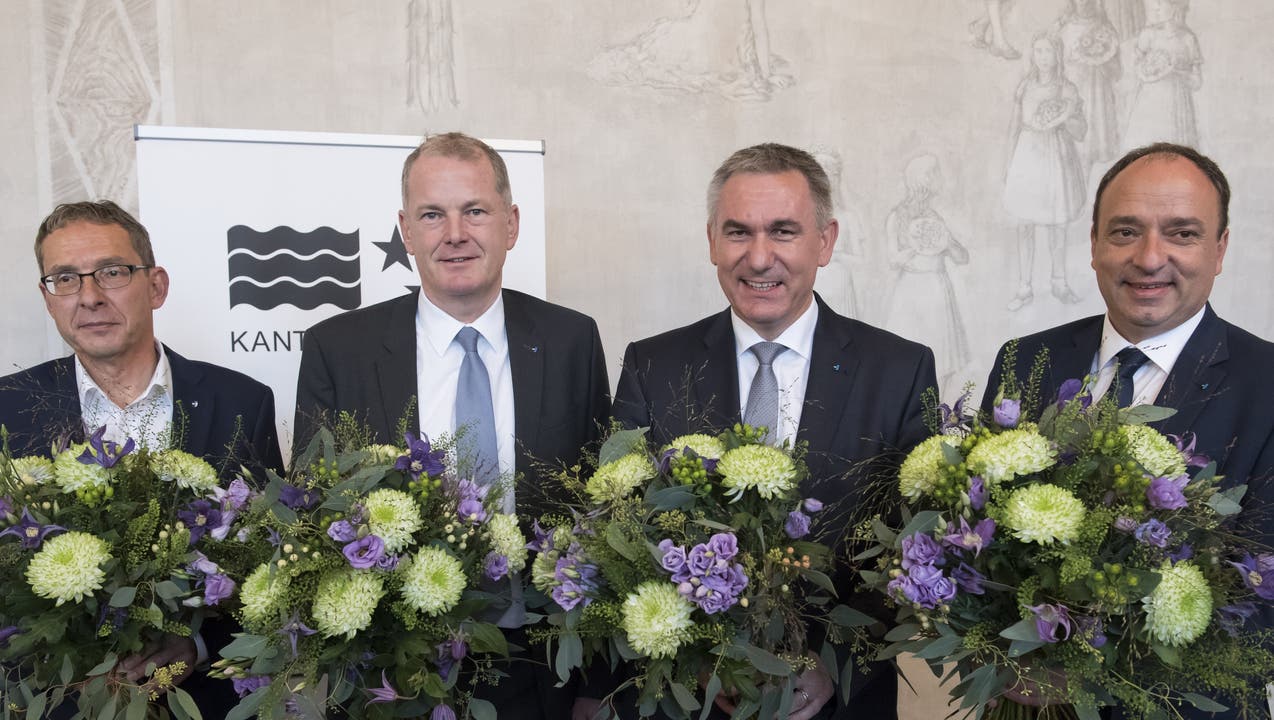 Urs Hofmann, Stephan Attiger, Alex Hürzeler (alle bisher) und Markus Dieth (neu) mit Blumen: Sie sind im ersten Wahlgang als Regierungsräte gewählt worden.