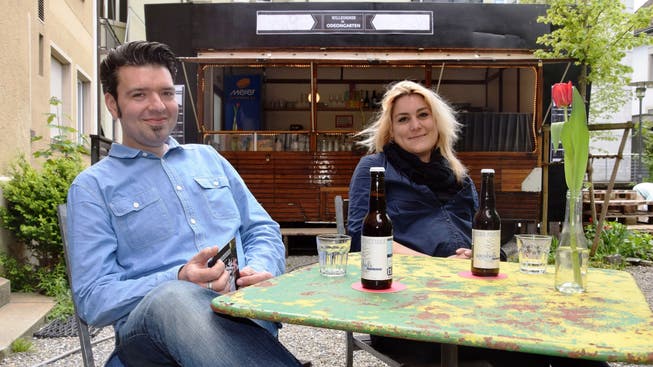 Betriebsleiter Stephan Filati und Barleiterin Gina Sträuli machen es sich bequem im Innenhof. Die Open-Air-Bar befindet sich in einem früheren Zirkuswagen.