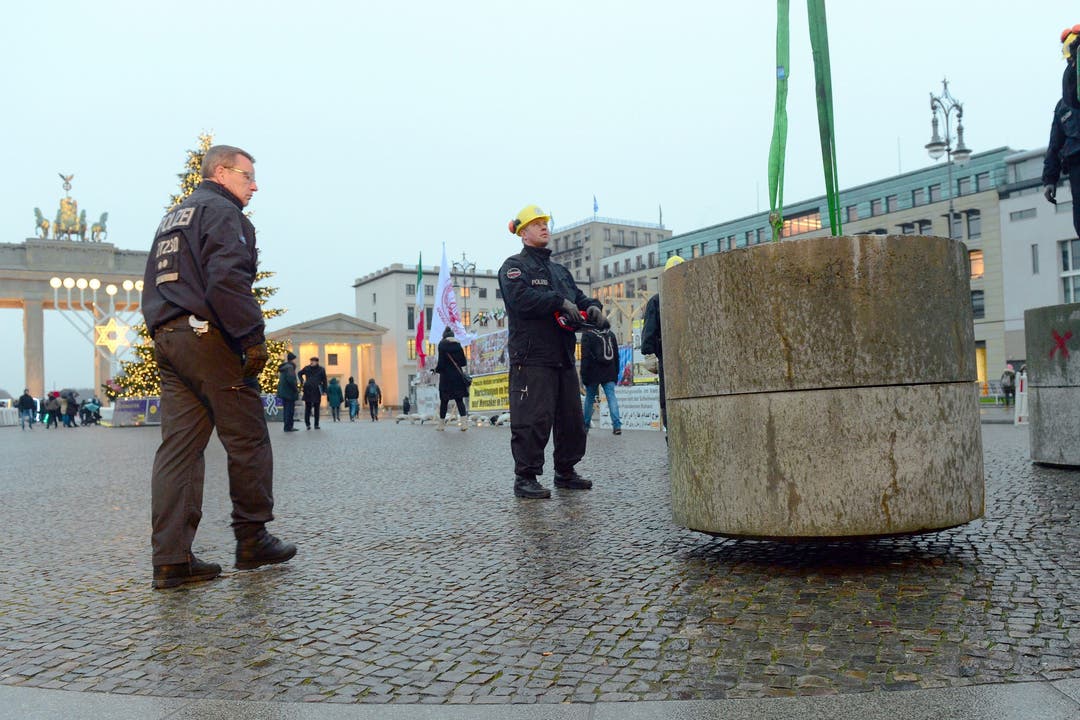 Polizeibeamte stellen Betonblöcke auf dem Pariser Platz vor dem Brandenburger Tor auf.