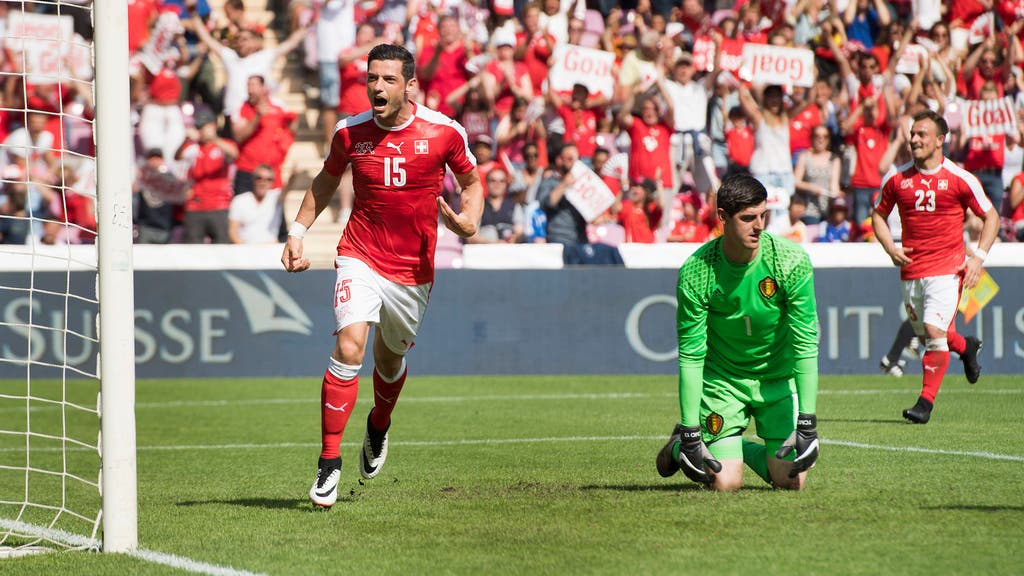 Blerim Dzemaili (l.) jubelt über seinen Treffer, Belgiens Torhüter Thibault Courtois sitzt geschlagen am Boden
