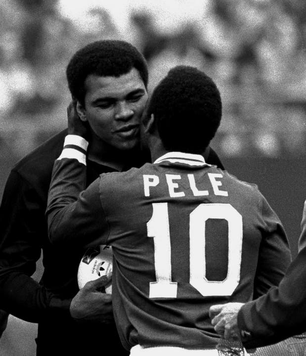 1977: Fussballer Pele umarmt Muhammad Ali.