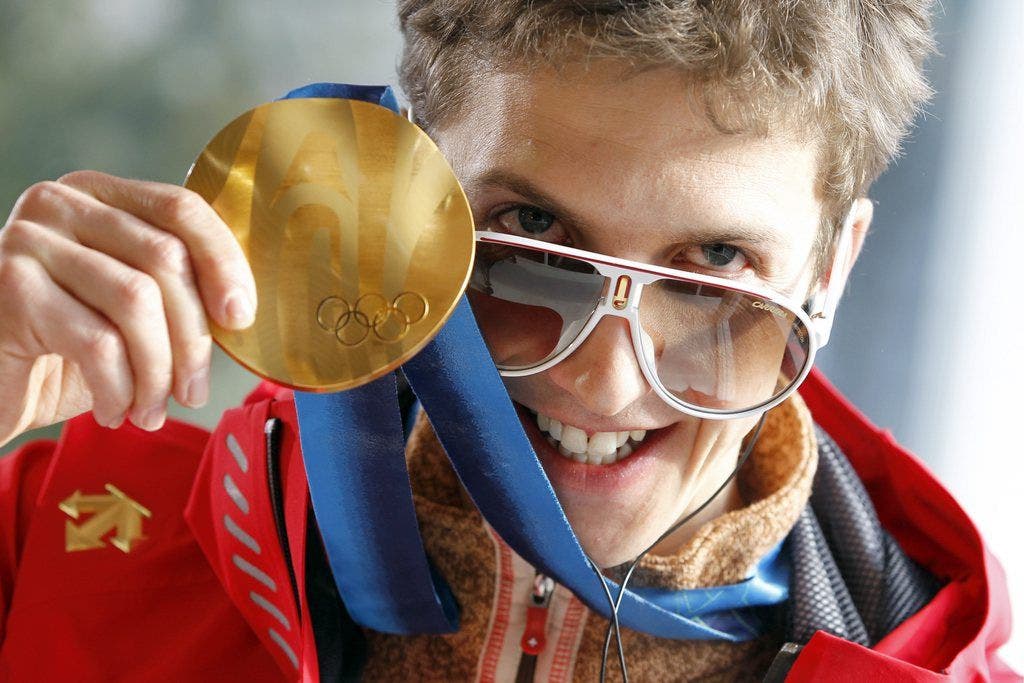 Simon Ammann zeigt stolz seine Goldmedaille, nachdem Gewinn auf der Normalschanze in Vancouver 2010