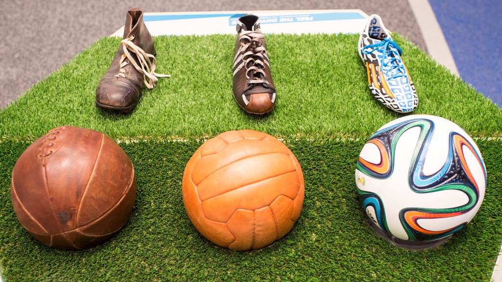 Drei Schuhe und drei Bälle zeigen, wie sich der Fussball in den letzten 100 Jahren gewandelt hat.