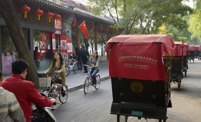 Bereit zur Erkundungstour: Touristen können in Peking selber in die Pedale treten. Velos und Rikscha-Taxis auf der Qianhai-Beiyan-Strasse am Qianhai-See. Foto: Getty Images