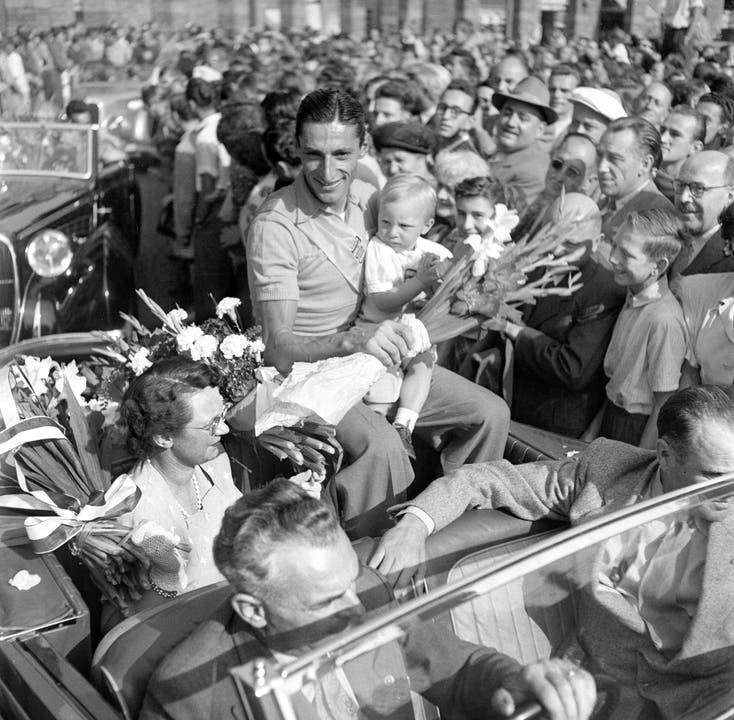 Ferdy Kübler – Bilder zu seinem Leben Der Schweizer Radrennfahrer Ferdy Kübler trifft im August 1950 nach seinem Gesamtsieg an der Tour de France am Bahnhof Zürich-Enge in Zürich ein, wo er von seiner Frau und seinem Sohn und einer Menschenmenge empfangen wird.