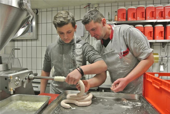 Schüler Mike packt in der Chämi-Metzg beim Wursten mit an – Fleischfachmann Fredy Adamovic unterstützt den 14-Jährigen. ces