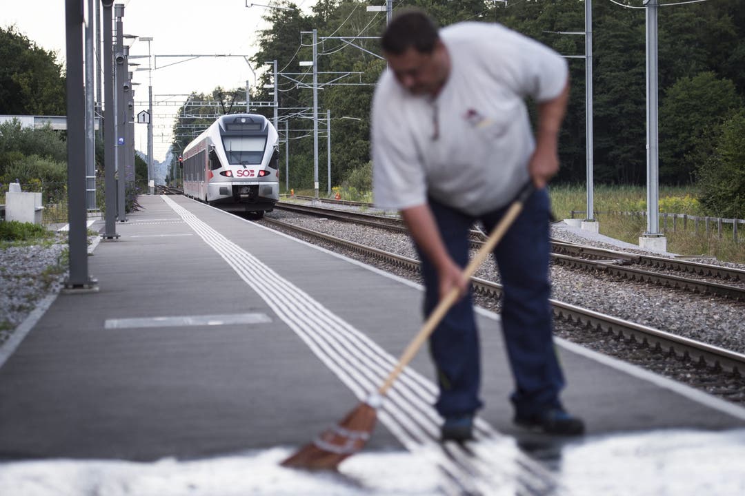 Arbeiter säubern den Bahnsteig.