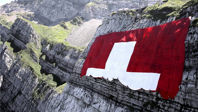 Kletterer rollen die grösste Schweizer Fahne der Welt (80×80 Meter) am Säntis aus. Wie aber gehts mit der Swissness, der Marke Schweiz, weiter? Rauf oder runter?key