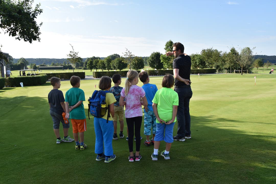 Steven Walther zeigt den Ferienpässlern die Weiten des Golfplatzes