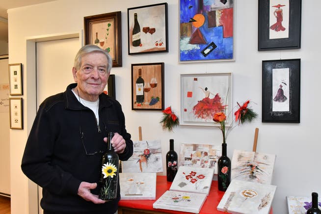 Walter Bucher mit dunklen Weinflaschen, verziert mit Blumenmotiven.