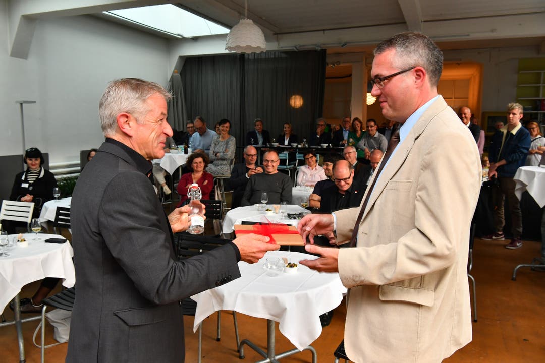 Buchfestival-Vereinspräsident Georg Berger (links) überreicht Regierungsrat und Landammann Remo Ankli ein Buch und ein Fläschchen mit Oltner Wasser.