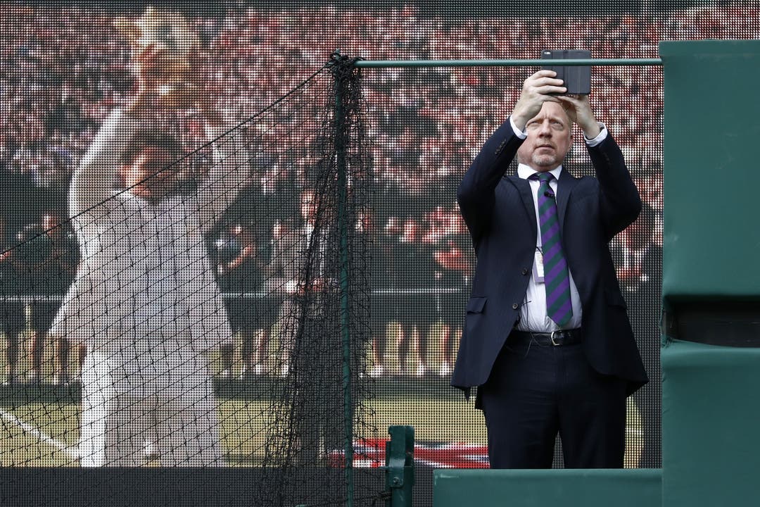 Tennis-Legende Boris Becker - er lebt in London - macht ein Foto von einem Screen, der Roger Federer zeigt.