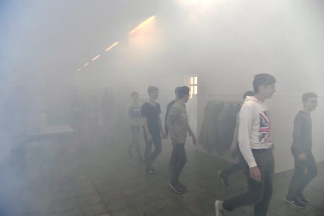 Im dichten Rauch verlassen die Schülerinnen und Schüler ihre Klassenzimmer und gehen nach draussen.
