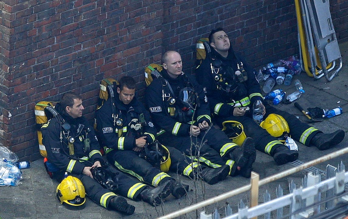 Diese Feuerwehrleute legen eine Pause ein, um wieder zu Atem zu kommen.