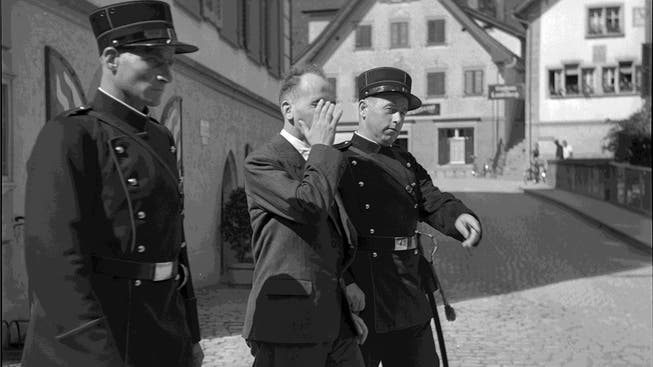 Polizisten bringen Hans Vollenweider zum Kantonsgericht Obwalden, 1940.