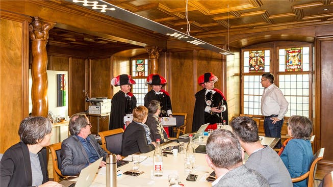 Die Dreierdelegation der Zunft zur Sankt Cordula übergibt dem Badener Stadtrat den jährlichen Obolus für die Reben-Pacht.
