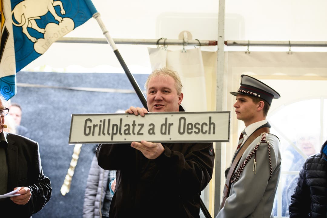 Urs Ledermann präsentiert das Schild für den "Grillplatz a der Oesch".