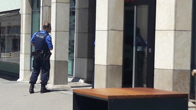 Polizist vor der UBS-Filiale in Wettingen, die am Mittag überfallen wurde.
