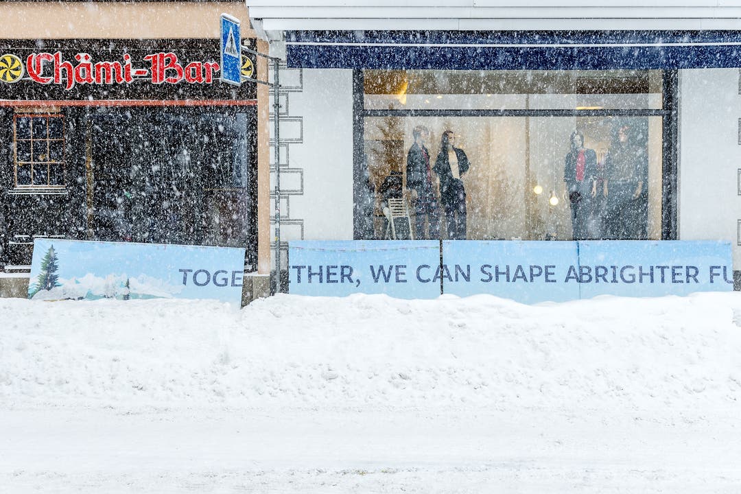 In Davos Platz werden bei heftigem Schneetreiben Läden zu temporären Firmendomizilen umgebaut.
