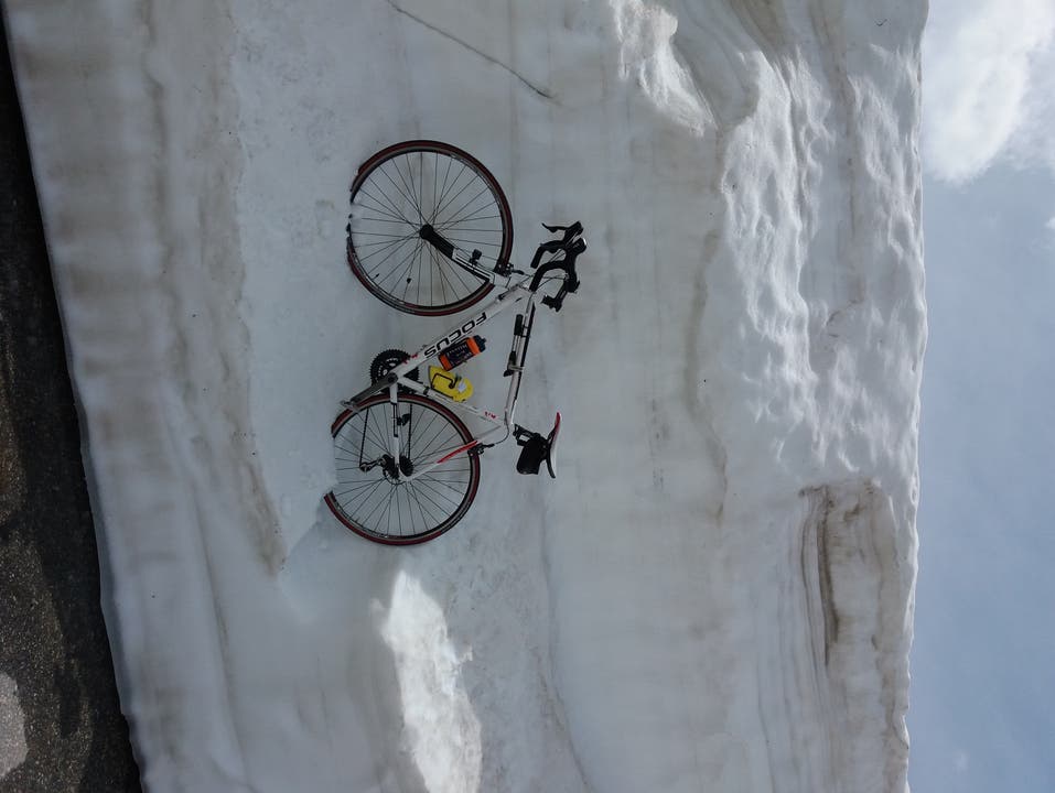 undefined Mein parkiertes Velo an der Schneemauer auf dem Gotthardpass