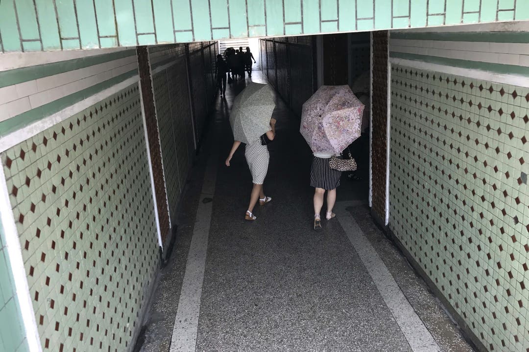 Alltag in Nordkorea - Impressionen Diese Frauen schützen sich mit Schirmen gegen die Sonneneinstrahlung.