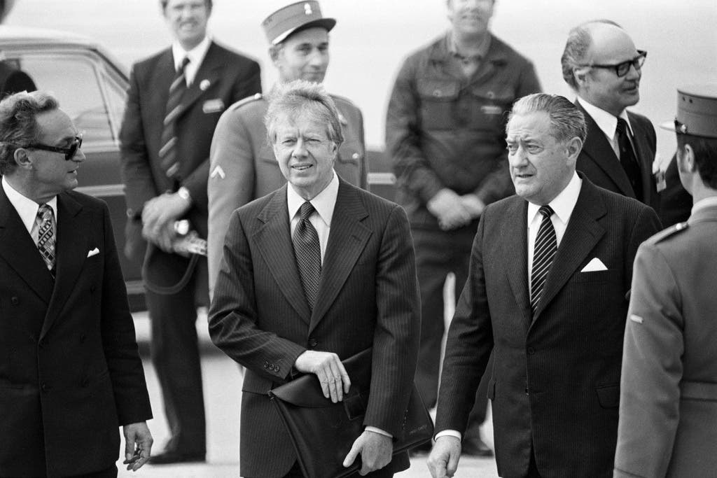 Der amerikanische Praesidenten Jimmy Carter, Mitte, und sein Aussenminister Cyrus Vance, Mitte rechts, werden am 9. Mai 1977 auf dem Flughafen von Genf-Cointrin empfangen. Carter wird in Genf mit dem syrischen Ministerpraesidenten Hafiz al-Assad zu Friedensverhandlungen im Nahostkonflikt zusammentreffen.