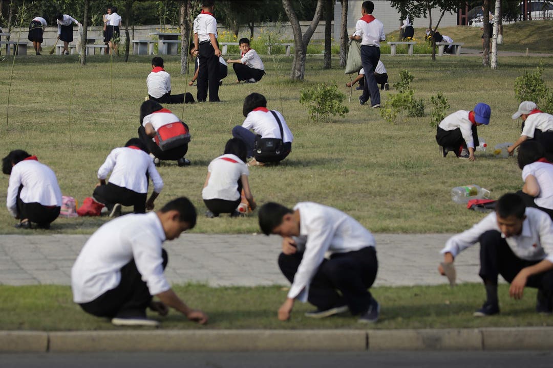 Alltag in Nordkorea - Impressionen Schulkinder pflegen einen Rasen.