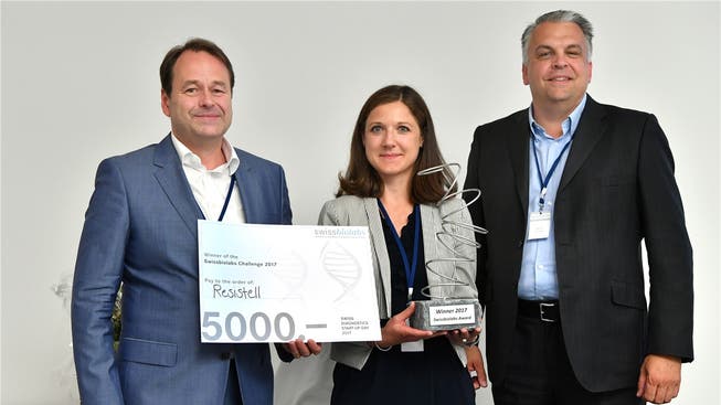 Danuta Cichocka von der Gewinnerfirma Resistell erhält aus den Händen von Jury-Präsident Derek Brandt (rechts) und Dirk Schneider, Präsident des Fördervereins Swissbiolabs, den mit 5000 Franken dotierten Swissbiolabs Award 2017.