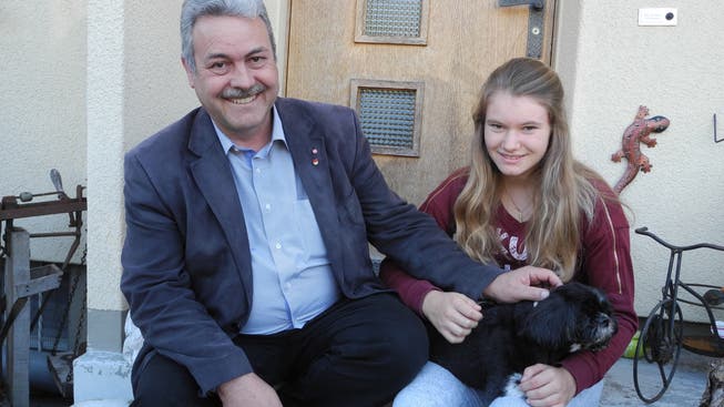 Markus Baumann streichelt mit seiner Tochter Sarah den Hund Kira, deren Leben er gerettet hat.