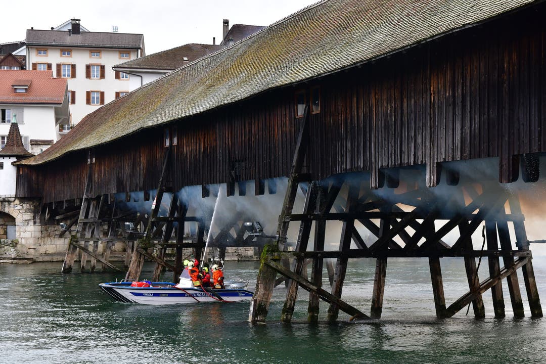 Die historische Holzbrücke in Olten brennt - die Feuerwehr löscht.