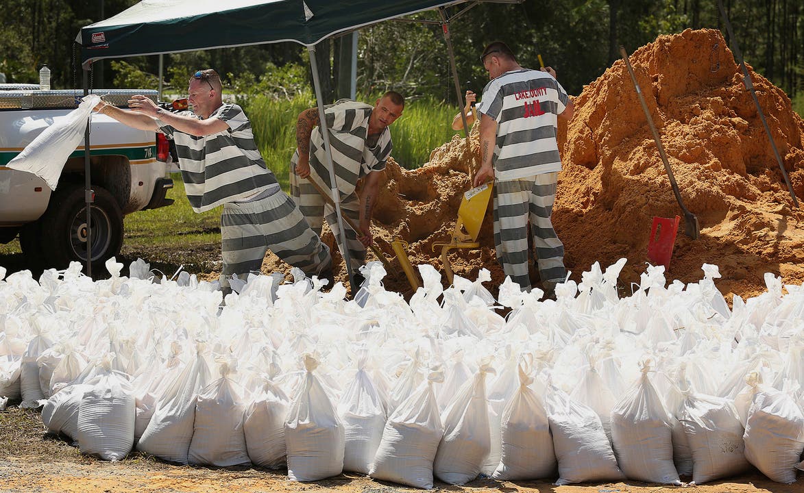Im US-Bundesstaat Florida füllen Häftlinge des Lake County Gefängnisses Sandsäcke.
