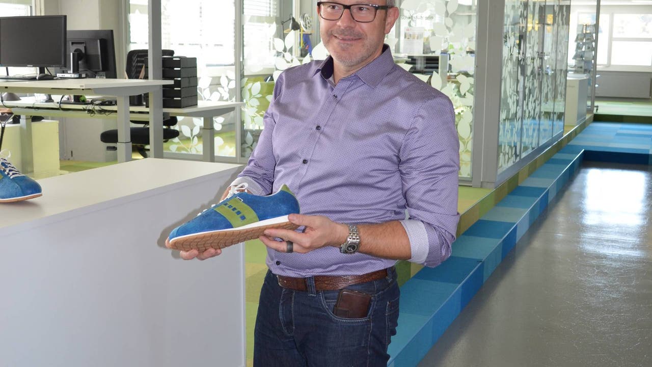 Karsten Bugmann präsentiert die Künzli-Schuhe in Spitex-Farben, die jeder Mitarbeitende zum 5-Jahrjubiläum erhält.